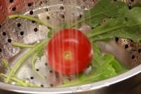 Rucola und Tomate im Sieb