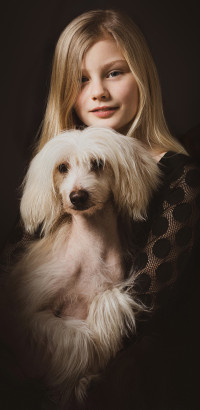 Portrait eines Mädchens mit Hund auf dem Schoß. Fotograf Enric Mammen